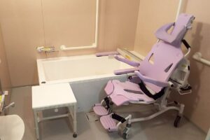 機能訓練室。紫色のリハビリテーション機器と白いテーブルが配置されている。